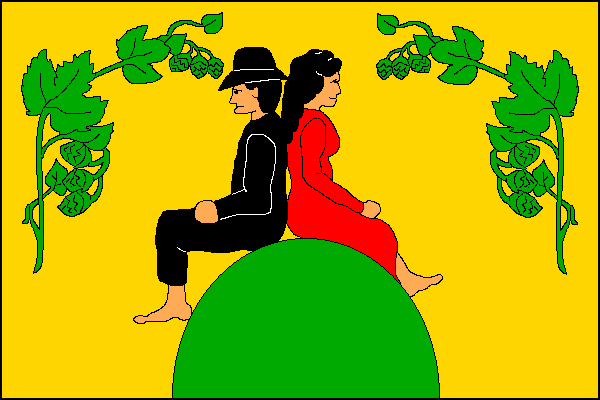 Žlutý list. Na dolním okraji listu zelená hora. Na ní sedí dvě zády se opírající bosé postavy - na žerďové straně muž s černými vlasy, kloboukem, halenou a kalhotami; na vlající straně žena s černými vlasy a v červených šatech. V horním rohu a horním cípu